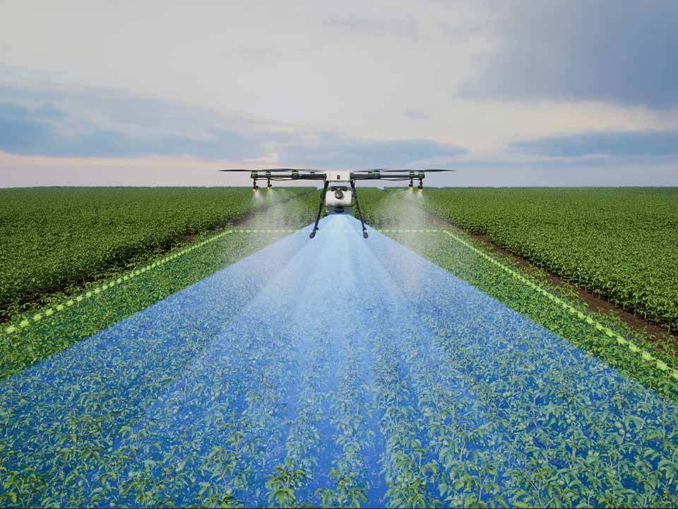 Agrospray-Portafolio-Dron-2 Dron agrícola pulverizando un cultivo verde bajo el cielo nublado, mostrando la tecnología de fumigación eficiente y automatizada.