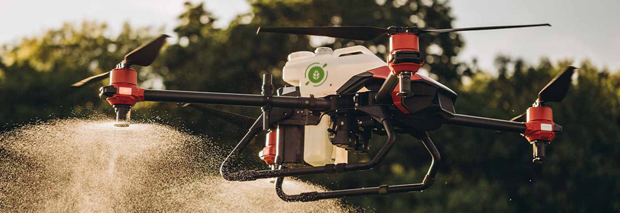 Agrospray-Portafolio-Dron Dron agrícola con isotipo de la marca de Agrospray en pleno vuelo, rociando fertilizante sobre un cultivo verde mientras vuela sobre el campo.