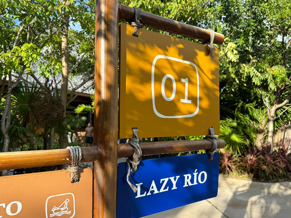 Jungala-Park-Portafolio-Detalle-Rio-Lento Señalética identificativo con el número '01' y señalización del 'Lazy Río', parte de la señalética en Jungala Aqua Experience, rodeada de vegetación tropical.