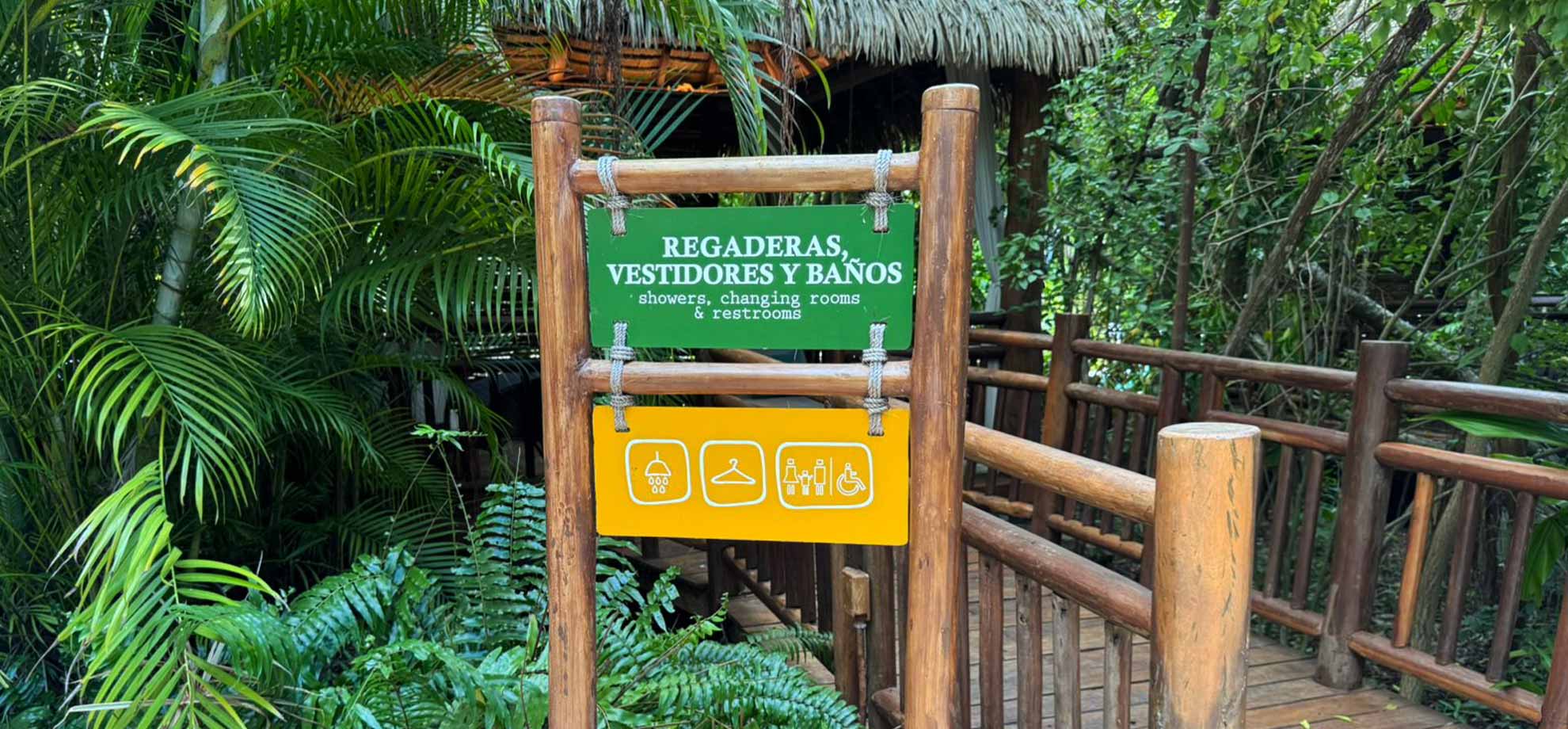 Jungala-Park-Portafolio-Regaderas Señalética de Jungala Aqua Experience indicando la ubicación de regaderas, vestidores y baños, con íconos gráficos y un entorno lleno de vegetación.