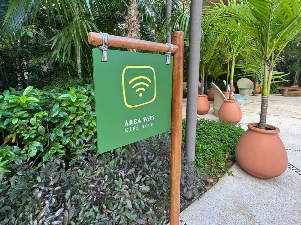 Jungala-Park-Portafolio-Wifi Señalética verde con ícono de WiFi, señalando el área de conexión inalámbrica en Jungala Aqua Experience, rodeada de vegetación tropical.