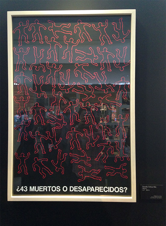 Póster enmarcado que presenta figuras humanas delineadas en rojo sobre un fondo negro, con la pregunta '¿43 muertos o desaparecidos?' como parte de la bienal de carteles de Ayotzinapa.